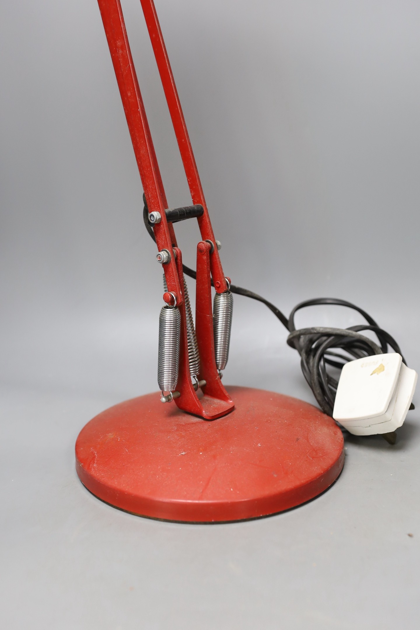 A red anglepoise desk lamp